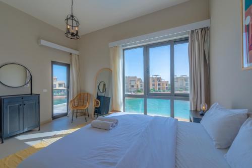ein Schlafzimmer mit einem großen Bett und einem großen Fenster in der Unterkunft Long Island Gouna 5BR Tawila Beach House & Pool in Hurghada