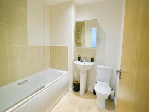 a bathroom with a white toilet and a sink at Pass the Keys King Bed Family Home With Parking WM Discounts in Manchester