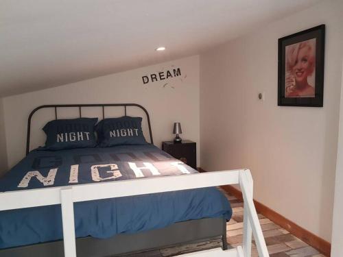 une chambre avec un lit avec un panneau sur le mur dans l'établissement Studio Champagne, à Châlons-en-Champagne