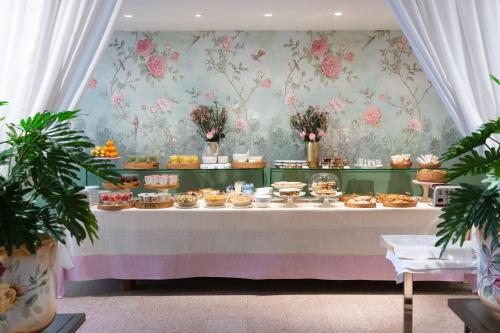 a table with a bunch of cakes and pastries at Hotel Gran Duca Di York in Milan