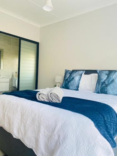 a bedroom with a large bed with towels on it at Joy Apartment@The Blyde in Pretoria
