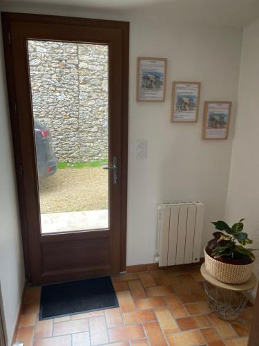 a door with a window and a plant in a room at Gîte de charme La Pocterie in Vouneuil-sur-Vienne