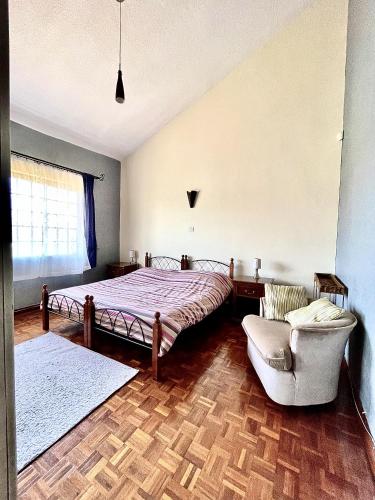 a bedroom with a bed and a couch and a chair at Westlands Escape-Homestay in Nairobi