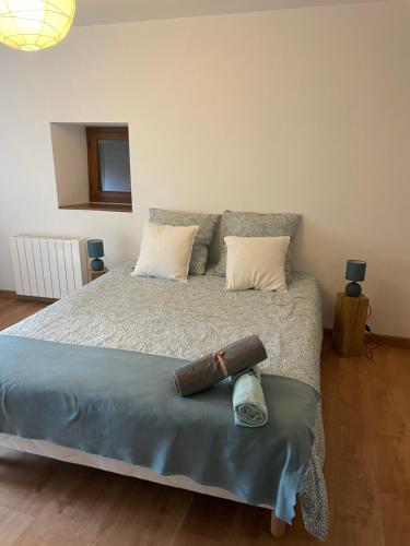 een slaapkamer met een groot bed met 2 kussens bij Gîte de charme La Pocterie in Vouneuil-sur-Vienne