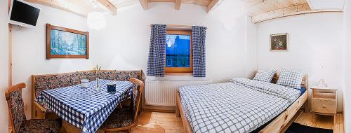 Zimmer mit 2 Tischen, einem Bett und einem Fenster in der Unterkunft Ekofarma Polná in Hazlov