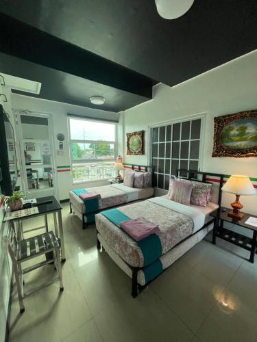 a bedroom with two beds and a large window at Italy Condotel Darasa in Tanauan