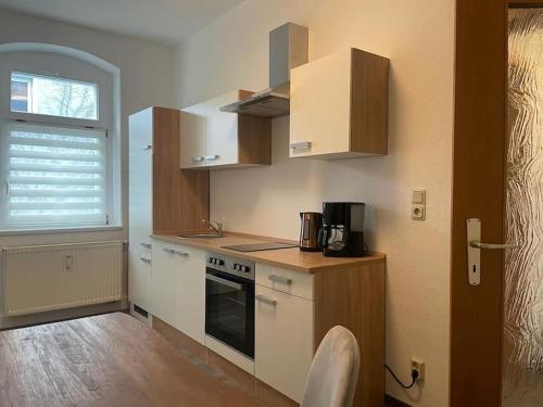 a kitchen with wooden cabinets and a stove top oven at Ferienwohnung 3S Real Estate in Freiberg