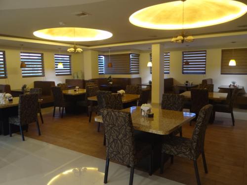 a dining room with tables and chairs and windows at Hotel Don Ruben in Chihuahua