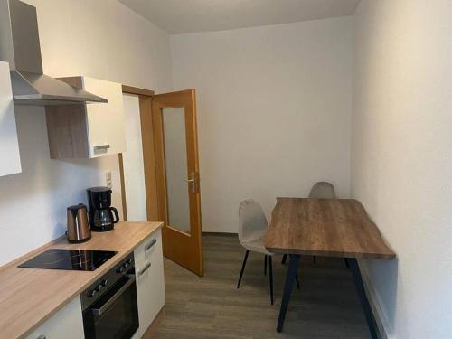 een kleine keuken met een houten tafel en een aanrecht bij Ferienwohnung 3S Real Estate in Freiberg