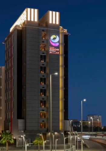 a building with a sign on the side of it at Ramada Encore Al Khobar Corniche in Al Khobar