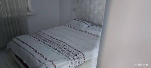 a white bed with white sheets and pillows at Chisinau Central Park in Chişinău