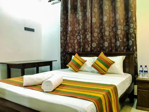una camera d'albergo con un letto e asciugamani di Queen's Villa a Habaraduwa Central
