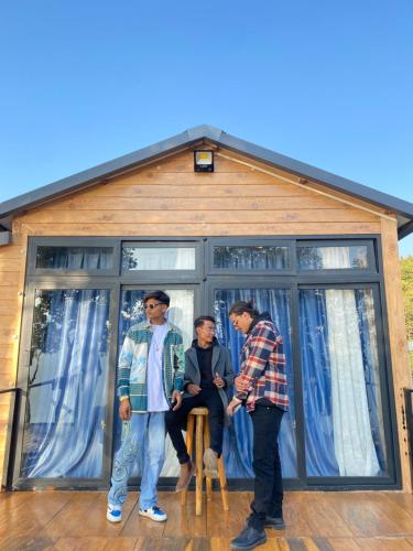 grupa trzech mężczyzn stojących przed domem w obiekcie (Sab’s villa )Forest cabin w mieście Pokhara