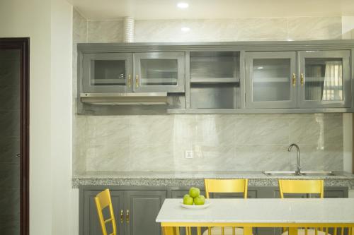 a kitchen with gray cabinets and a table with fruit on it at Try Residence, The Elysée Koh Pich in Phnom Penh