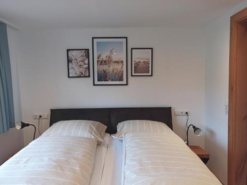a bed with three pictures on the wall above it at Apartment Sonnenwinkl in Kössen