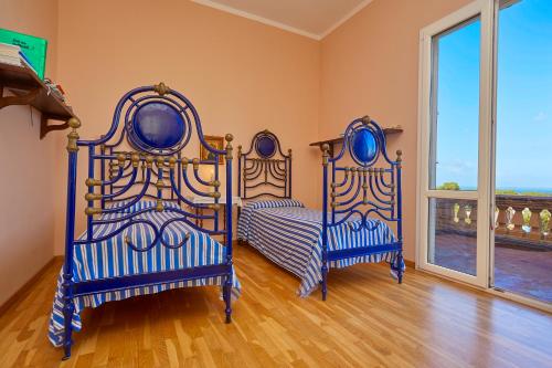 two beds in a room with a window at Villa Maria in Marsala