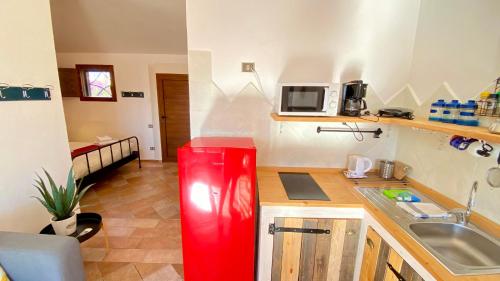a kitchen with a red refrigerator in a room at Residence La Rosa in Porto San Paolo