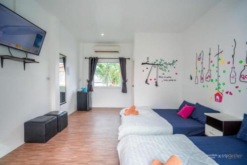 uma sala de estar com uma cama e uma televisão em PloyPhailin พลอยไพรินรีสอร์ท em Ko Larn