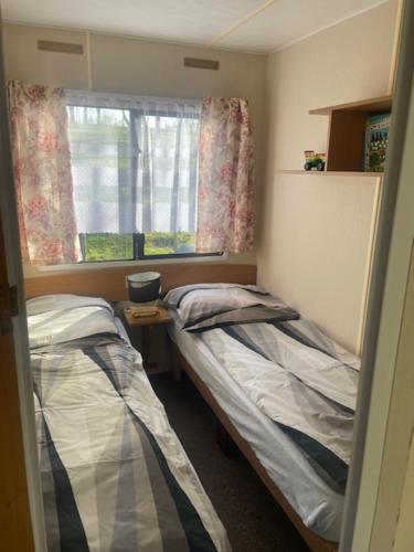 a small room with two beds and a window at Dolina Trzech Stawów in Połczyn-Zdrój