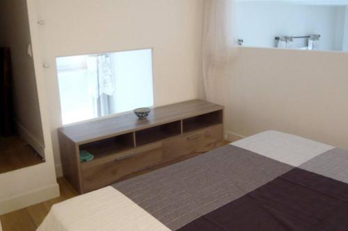 um pequeno quarto com uma cama e uma janela em LE REGRATTIER ST LOUIS em Paris