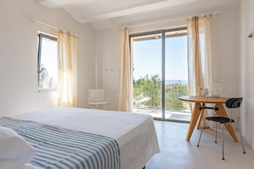 a bedroom with a bed and a table and a window at Casale Valverde in Alghero