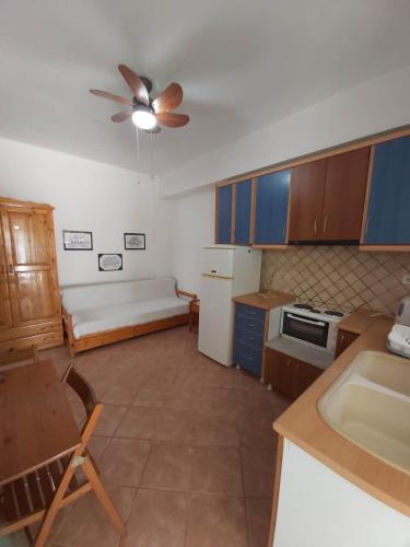 a kitchen with a couch and a ceiling fan at O&A Kallithea in Kallithea Halkidikis