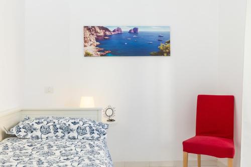 a bedroom with a bed and a red chair at Residence Sorrento 2 in Sorrento