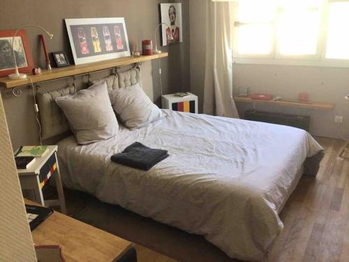 - une chambre avec un lit avec une étagère au-dessus dans l'établissement Appt 3 chambres hyper centre très calme très clair quartier place Royale, parking gratuit, à Nantes