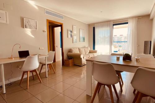 sala de estar con mesa, sillas y sofá en Apto. luminoso con vistas en playa de La Patacona en Valencia
