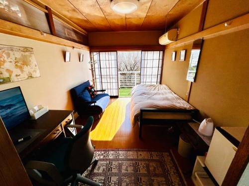 een kleine kamer met een bed, een bureau en een stoel bij Sakura house in Kyoto