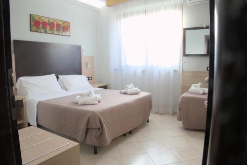 a bedroom with two beds with towels on them at Hotel Dei Tartari in Guidonia