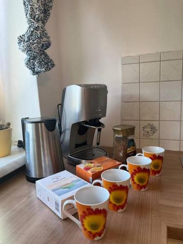 uma mesa com três chávenas de café e uma máquina de café em Niklasdorf Bergblick/Erholung em Niklasdorf