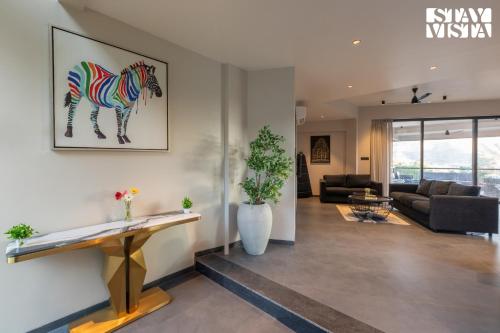 a living room with a painting of a horse on the wall at StayVista's Terra Tints - Mountainside Cabin with Private Pool, Deck & Games Room in Trimbak