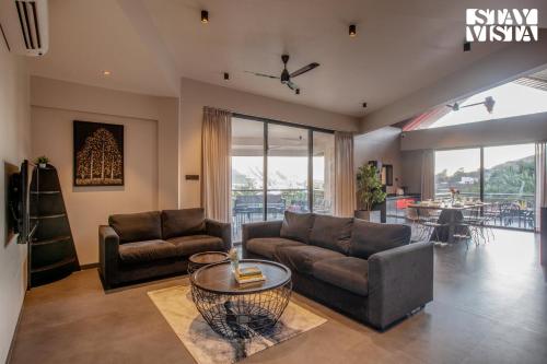 a living room with a couch and a table at StayVista's Terra Tints - Mountainside Cabin with Private Pool, Deck & Games Room in Trimbak