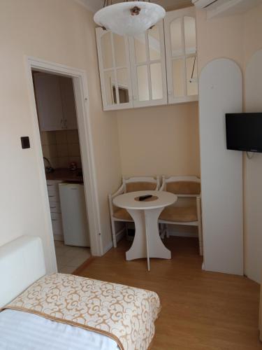 a small room with a table and a kitchen at Apartman Orgona in Siófok