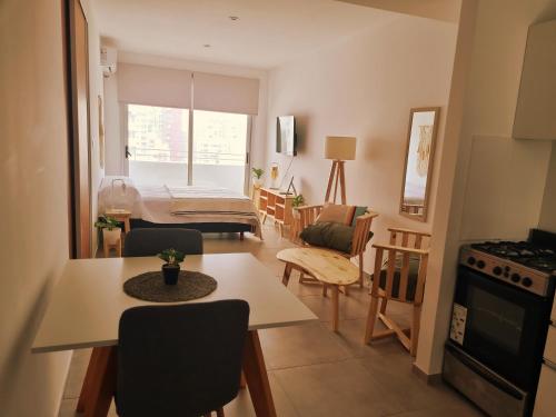 uma cozinha e sala de estar com uma mesa e um quarto com uma cama em Excelente Apartamento Centro Opcional Cochera by Lofter em La Plata