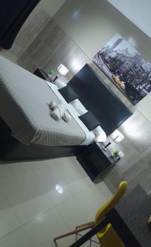 a bedroom with a bed and a yellow chair at Hotel La Terminal in San Miguel de Tucumán