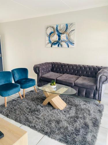 a living room with a couch and two chairs at Joy Apartment@The Blyde in Pretoria