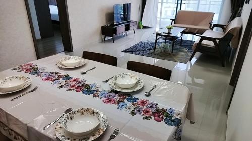 a white table with plates and flowers on it at 清心小舍03 in Kampong Pok Kechil