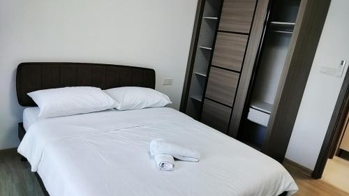 a white towel is sitting on a bed at 清心小舍03 in Kampong Pok Kechil