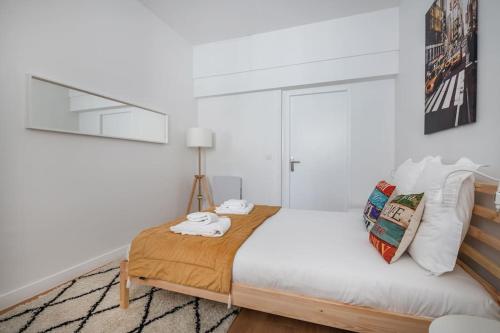 - une chambre avec un grand lit aux murs blancs dans l'établissement Le Terminal - Bel appartement quartier Sacré-Coeur, à Bordeaux