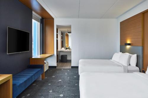 a hotel room with two beds and a television at Aloft Nashville Franklin in Franklin