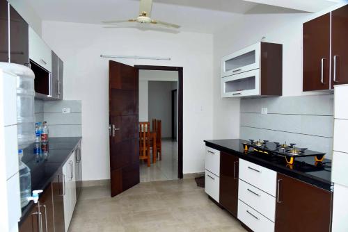 uma cozinha com um balcão preto num quarto em Krishna Dhwani Apartments em Tellicherry