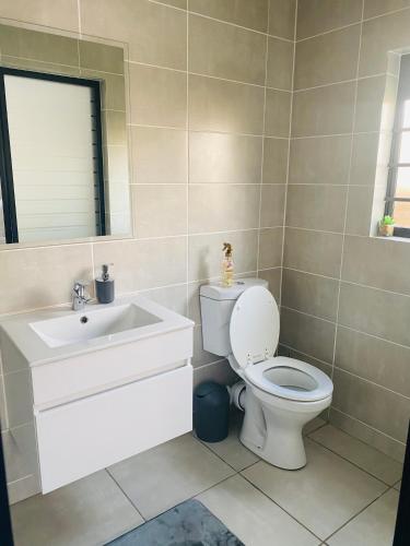 a bathroom with a toilet and a sink at Joy Apartment@The Blyde in Pretoria