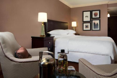 a hotel room with a bed and a table at Sheraton DFW Airport Hotel in Irving