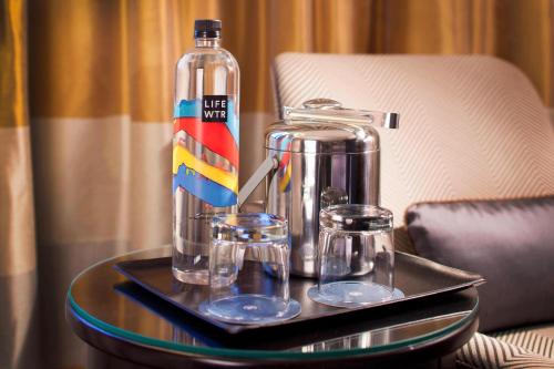 a tray with a bottle and two glasses on a table at Sheraton DFW Airport Hotel in Irving