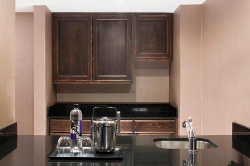 a kitchen with wooden cabinets and a counter top at Sheraton DFW Airport Hotel in Irving