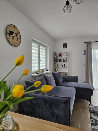 a blue couch in a living room with yellow flowers at Noclegi na Słonecznym Wzgórzu in Lądek-Zdrój