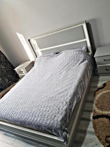 a bed in a bedroom with a gray comforter at Алматы квартира. 31 in Almaty