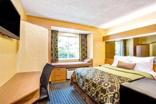 a hotel room with a bed and a window at Microtel Inn & Suites Newport News in Newport News